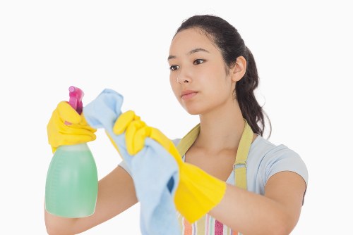 Cleaner working in a Putney office corridor with access and scheduling considerations