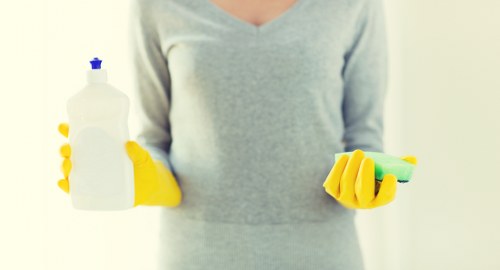 Local window cleaner working on upper-floor windows in Putney